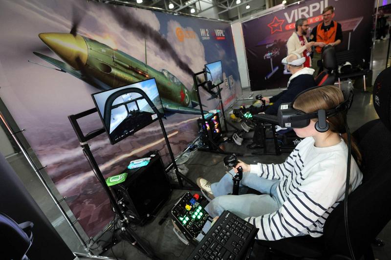 Ihminen pelaa virtual reality -lasit päässään tietokonepeliä.